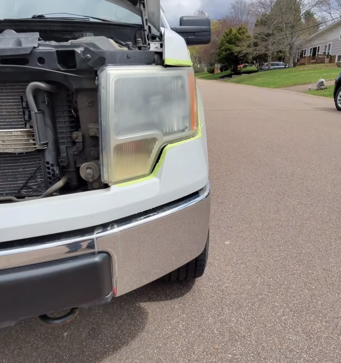 Yellowed foggy headlight before restoration on white Ford F-150
